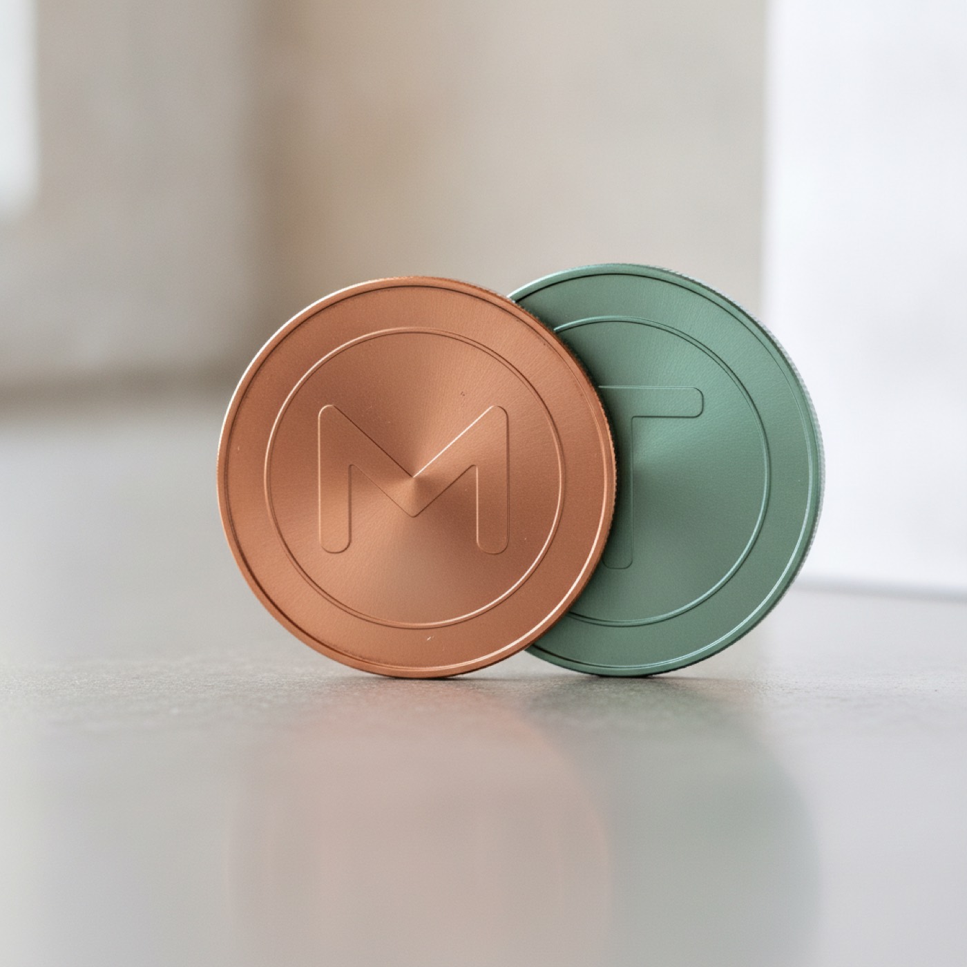 A Tether coin and a Monero coin lying side by side under soft daylight